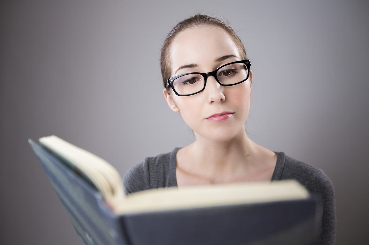 メガネの女性が本を読んでいる
