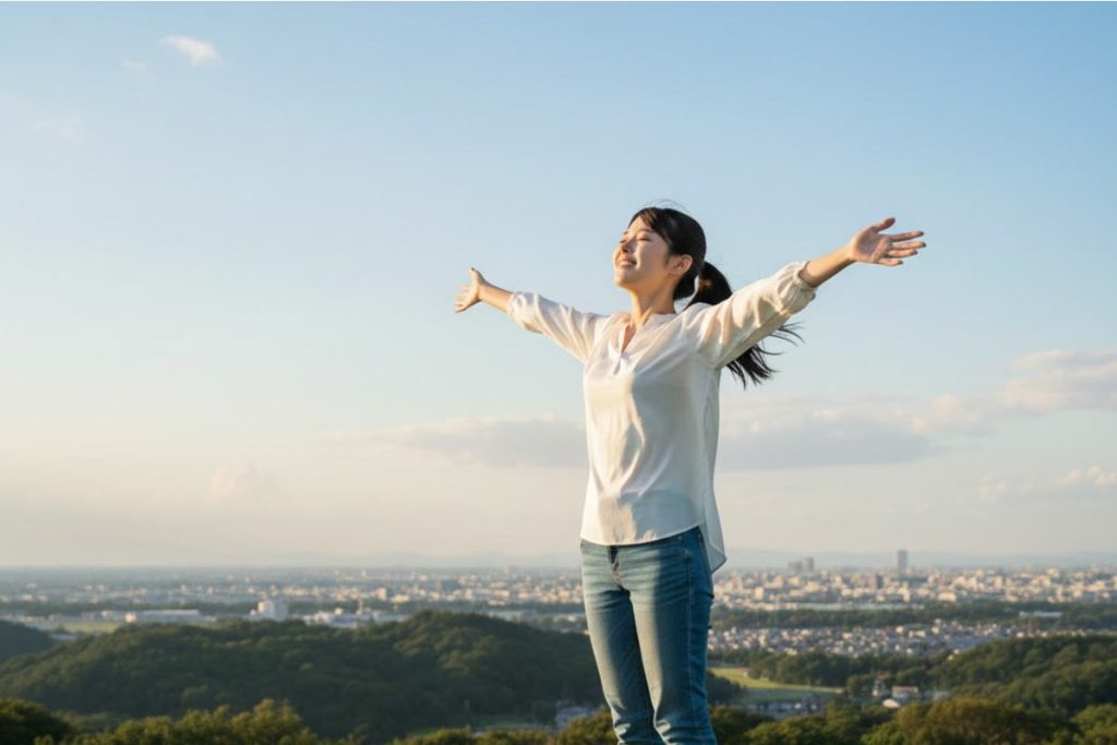 大空に両手を広げている女子学生